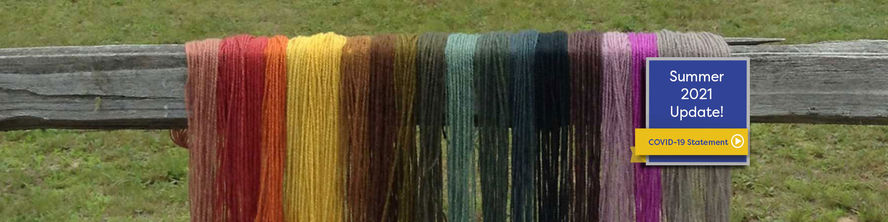 multi colored dyed wool drying on wooden fence